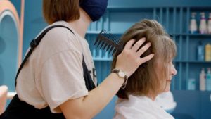 femme se fait brosser les cheveux chez le coiffeur